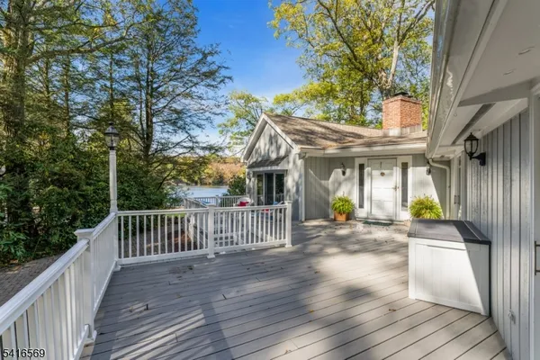 a view of a house with wooden deck and furniture