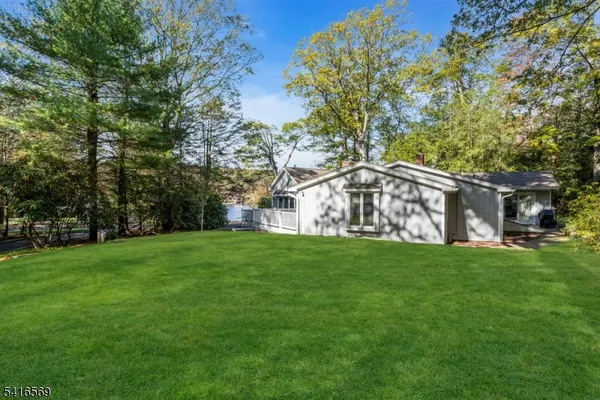 a view of a big house with a big yard and large trees