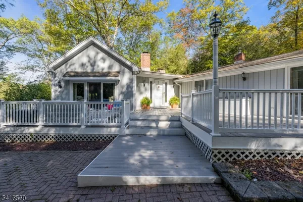 a view of a brick house with a small yard and wooden fence