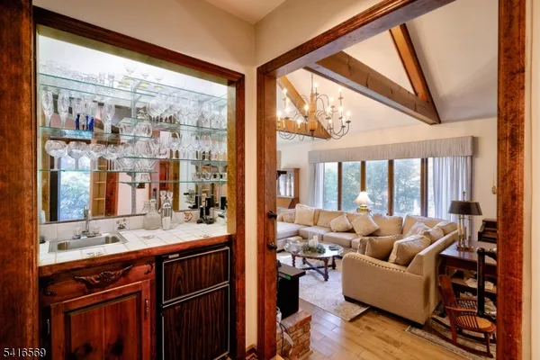 a living room with furniture large windows and wooden floor