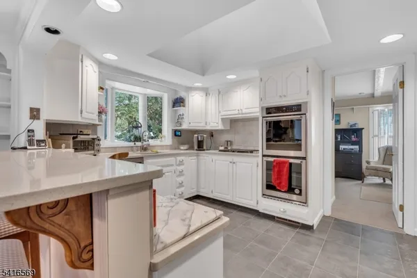 a kitchen with stainless steel appliances kitchen island granite countertop a refrigerator stove top oven and sink