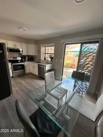 a kitchen with stainless steel appliances kitchen island granite countertop a stove and a view of living room
