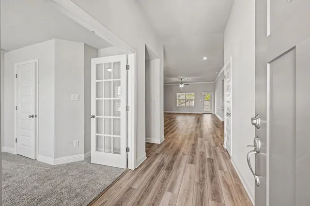 a view of empty room with wooden floor and fan
