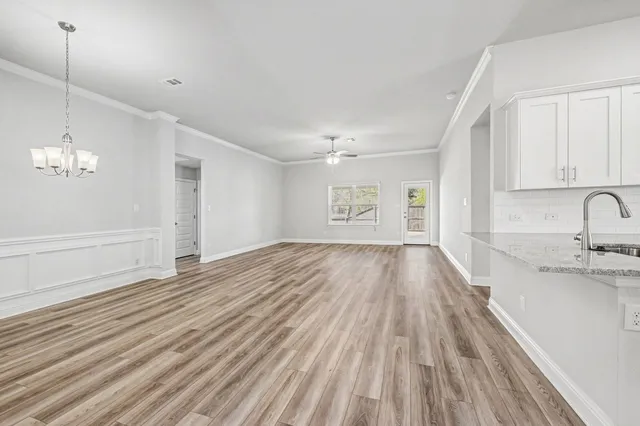 a view of empty room with wooden floor and window