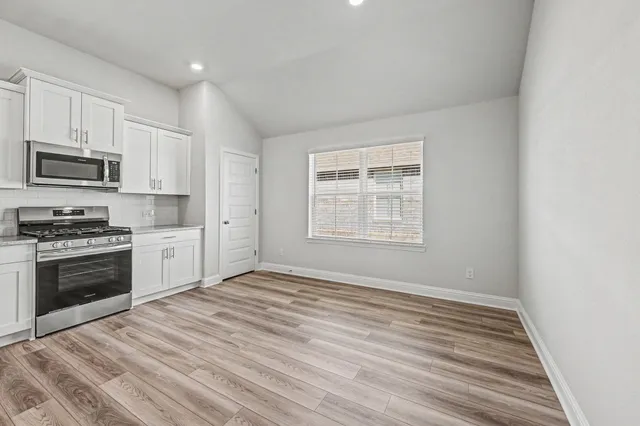 a kitchen with stainless steel appliances granite countertop a stove and a refrigerator