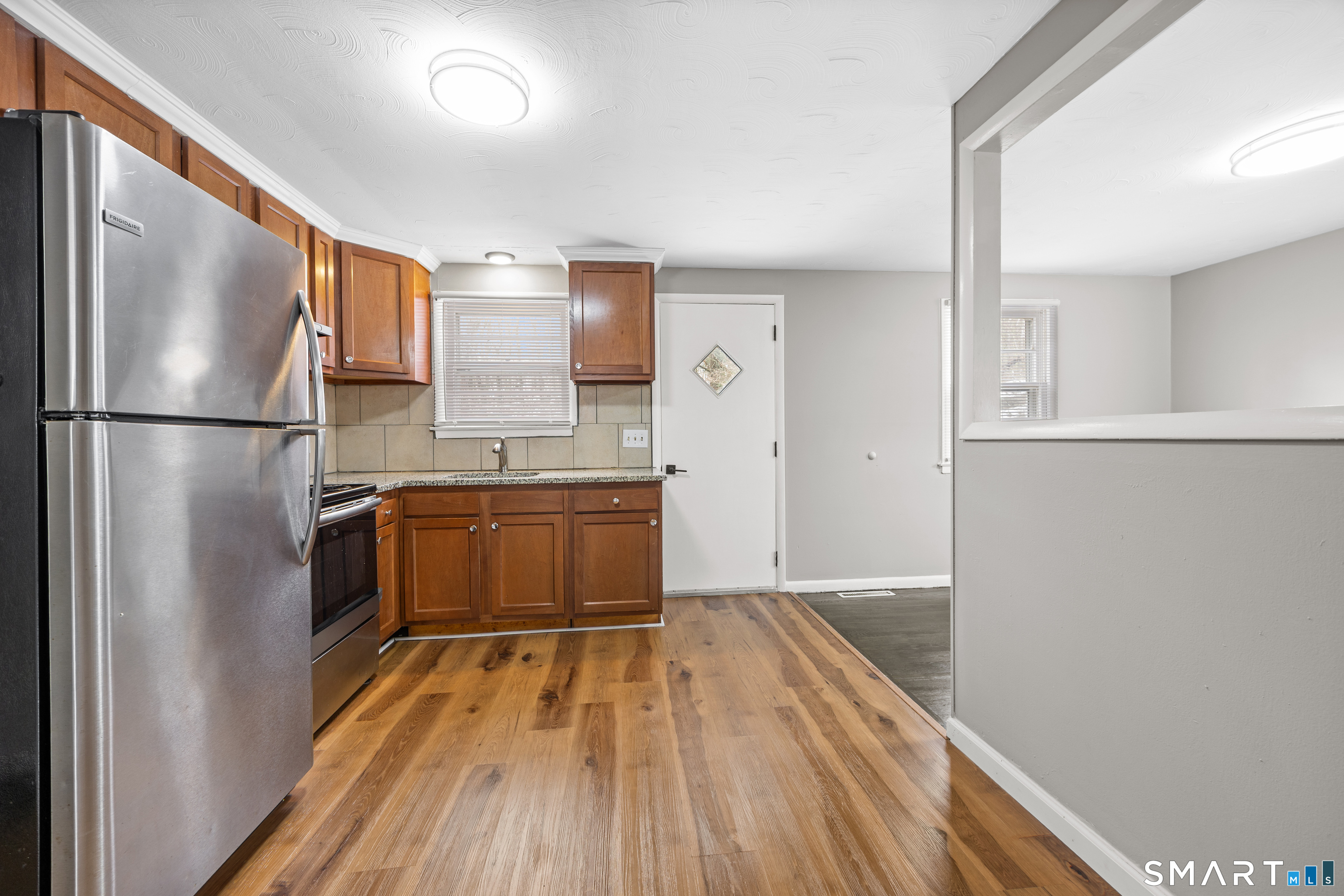 175 Devonwood Drive Waterbury, CT 06708 - Photo 11 of 30 a kitchen with wooden floors stainless steel appliances a refrigerator and a stove top oven