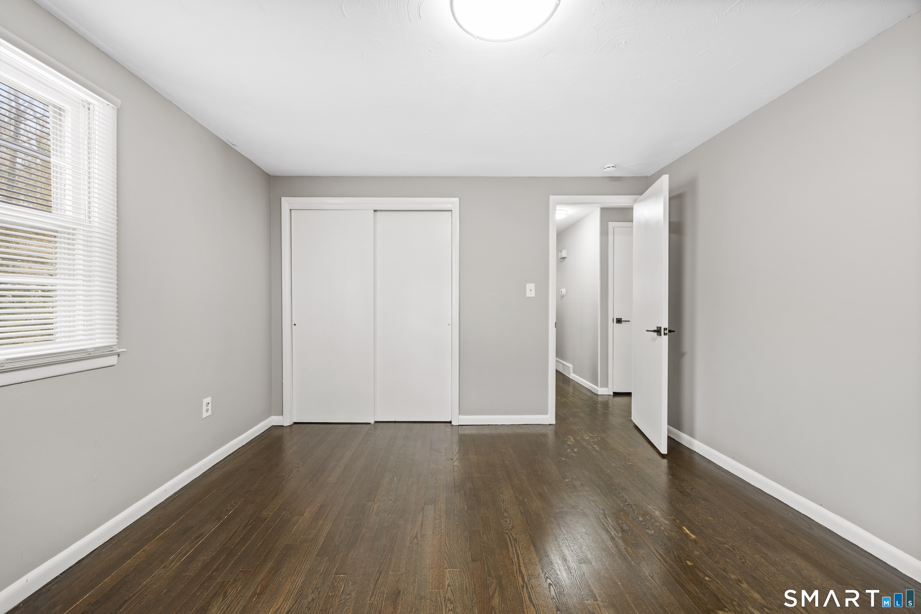 175 Devonwood Drive Waterbury, CT 06708 - Photo 15 of 30 an empty room with wooden floor and windows
