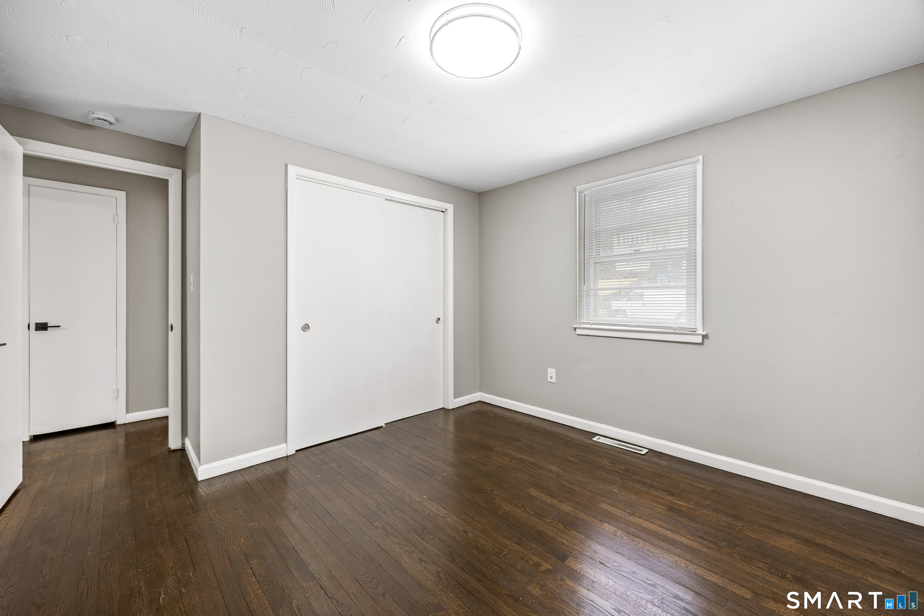 175 Devonwood Drive Waterbury, CT 06708 - Photo 18 of 30 an empty room with wooden floor and windows