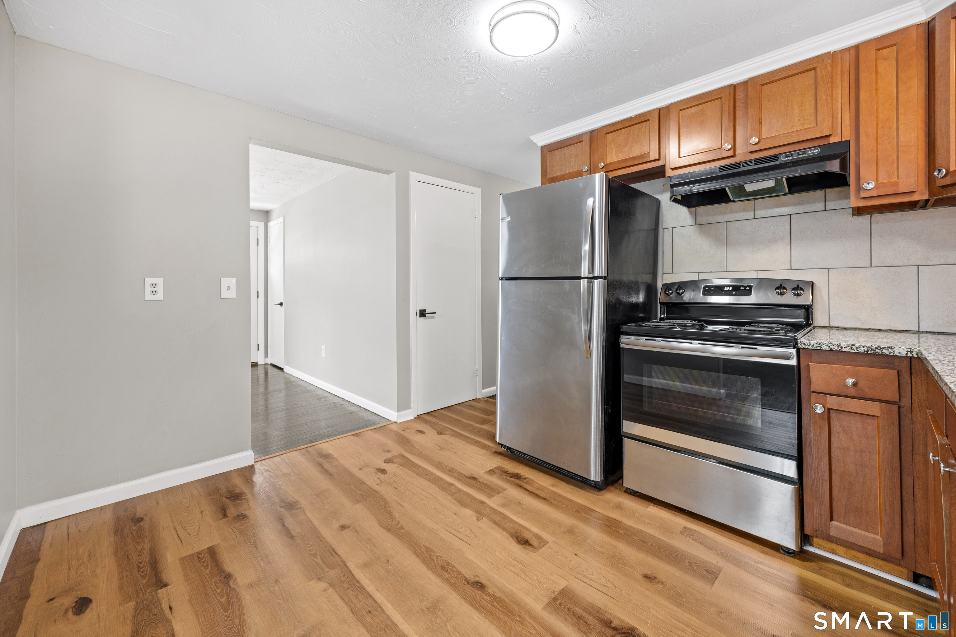 175 Devonwood Drive Waterbury, CT 06708 - Photo 10 of 30 a kitchen with granite countertop wooden cabinets stainless steel appliances and a counter space