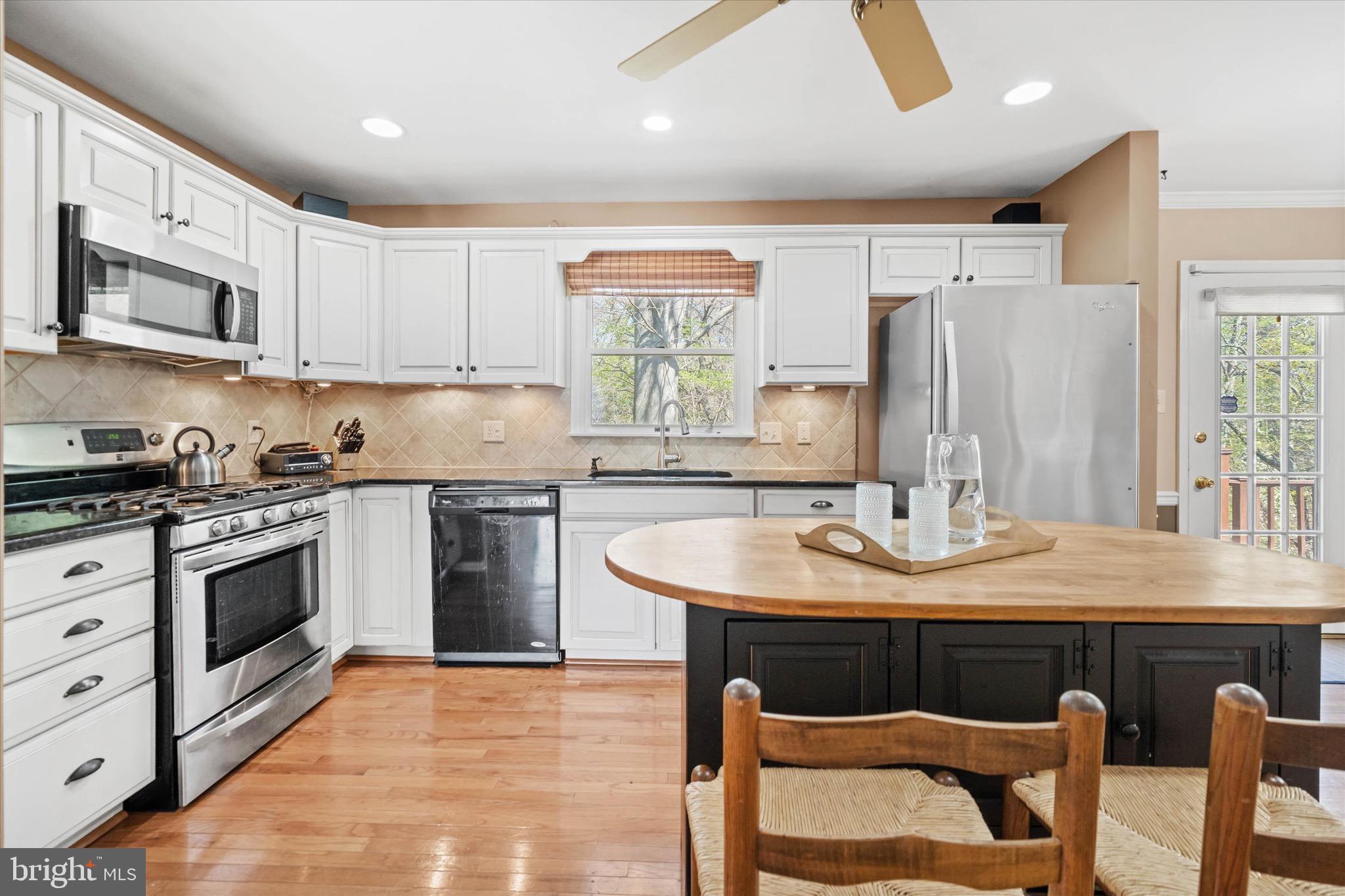 701 Christopher Drive Middletown, DE 19709 - Photo 15 of 57 a kitchen with stainless steel appliances granite countertop a kitchen island hardwood floor sink stove dining table and chairs