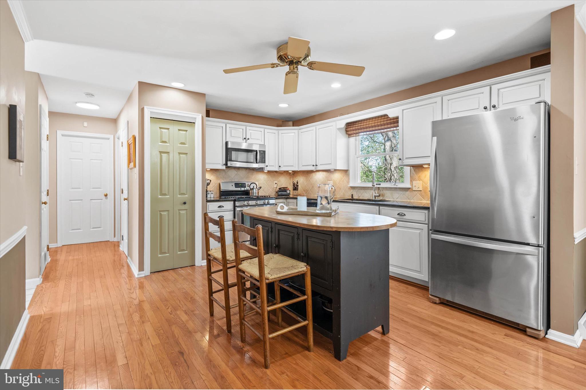 701 Christopher Drive Middletown, DE 19709 - Photo 17 of 57 a kitchen with kitchen island wooden floors white appliances and cabinets