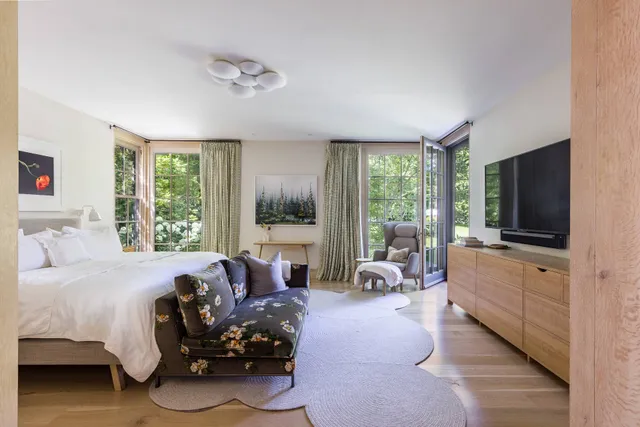 a bedroom with furniture and a large window