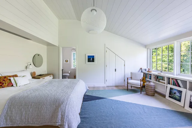 a bedroom with furniture and a large window