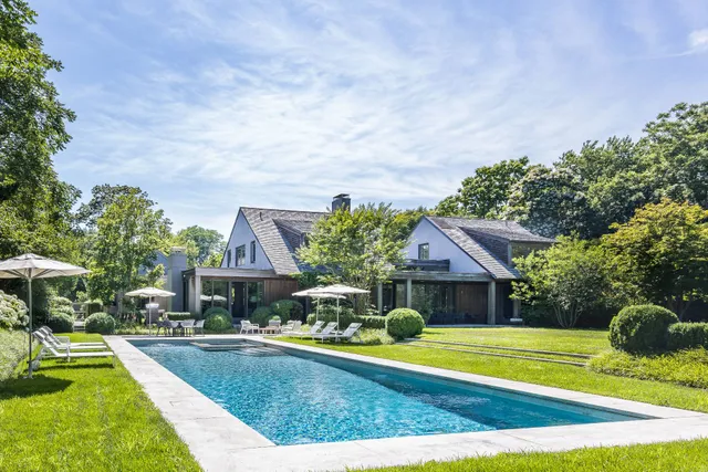 a view of house with garden space and swimming pool