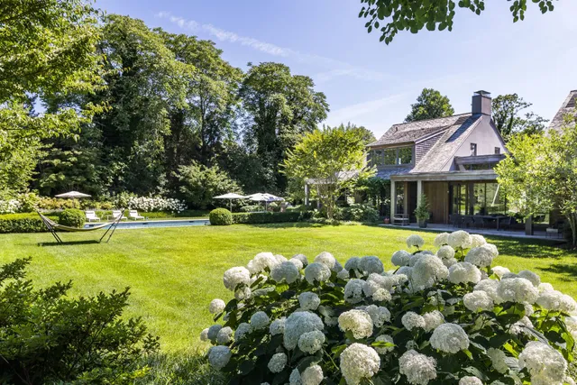 a front view of a house with swimming pool and sitting area
