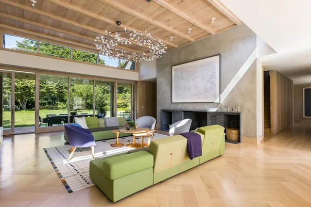 a living room with fireplace furniture and a large window