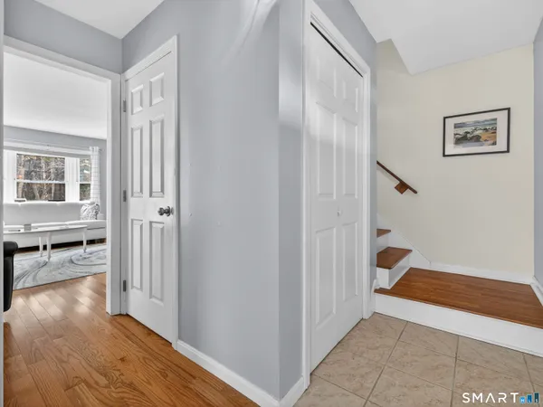 a view of a hallway with wooden floor and a living room