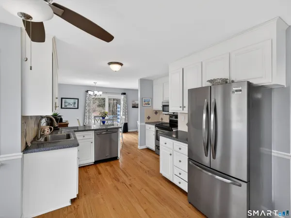 a kitchen with a refrigerator cabinets and wooden floor