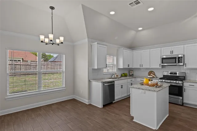 a kitchen with stainless steel appliances granite countertop a stove a sink dishwasher and a refrigerator