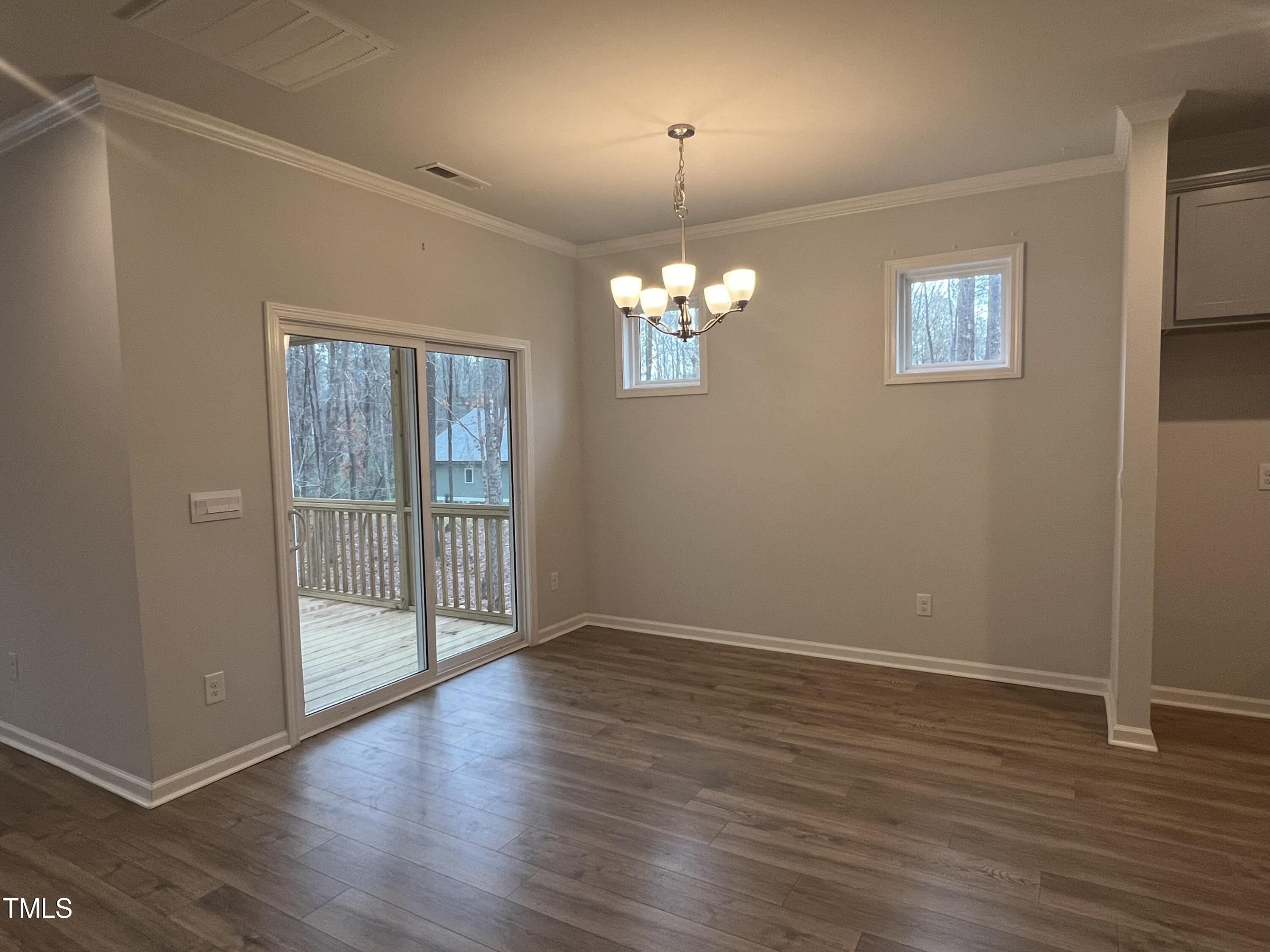 117 Clear Water Road Louisburg, NC 27549 - Photo 14 of 34 an empty room with wooden floor chandelier and windows