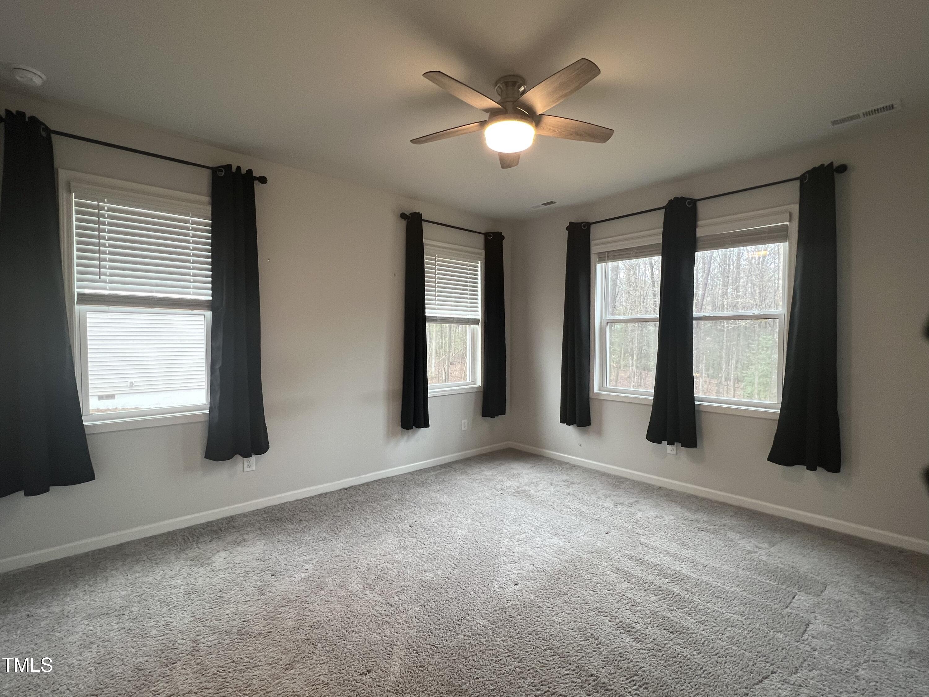 117 Clear Water Road Louisburg, NC 27549 - Photo 17 of 34 an empty room with windows and chandelier fan