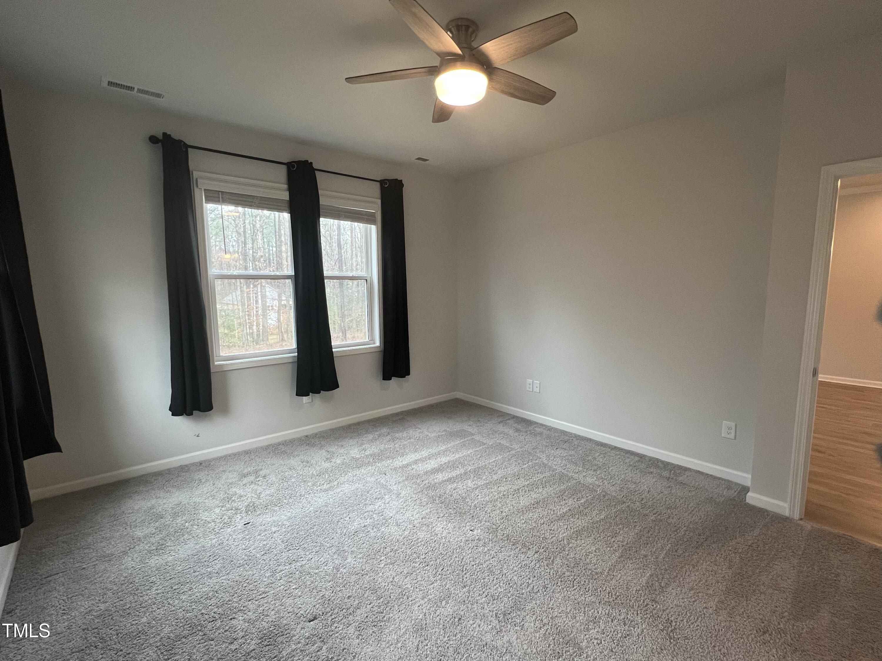 117 Clear Water Road Louisburg, NC 27549 - Photo 18 of 34 an empty room with chandelier fan and windows