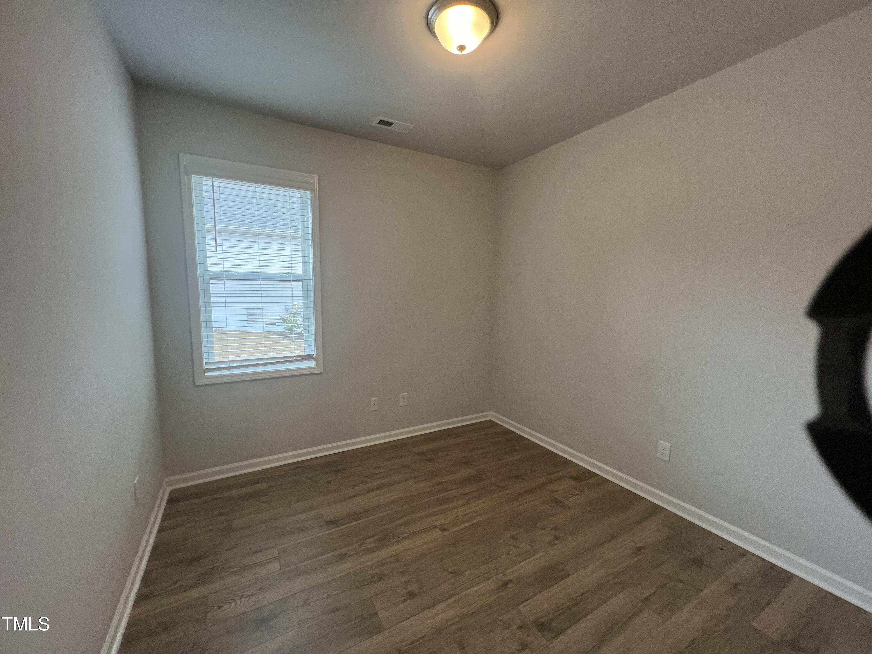 117 Clear Water Road Louisburg, NC 27549 - Photo 25 of 34 an empty room with wooden floor and windows