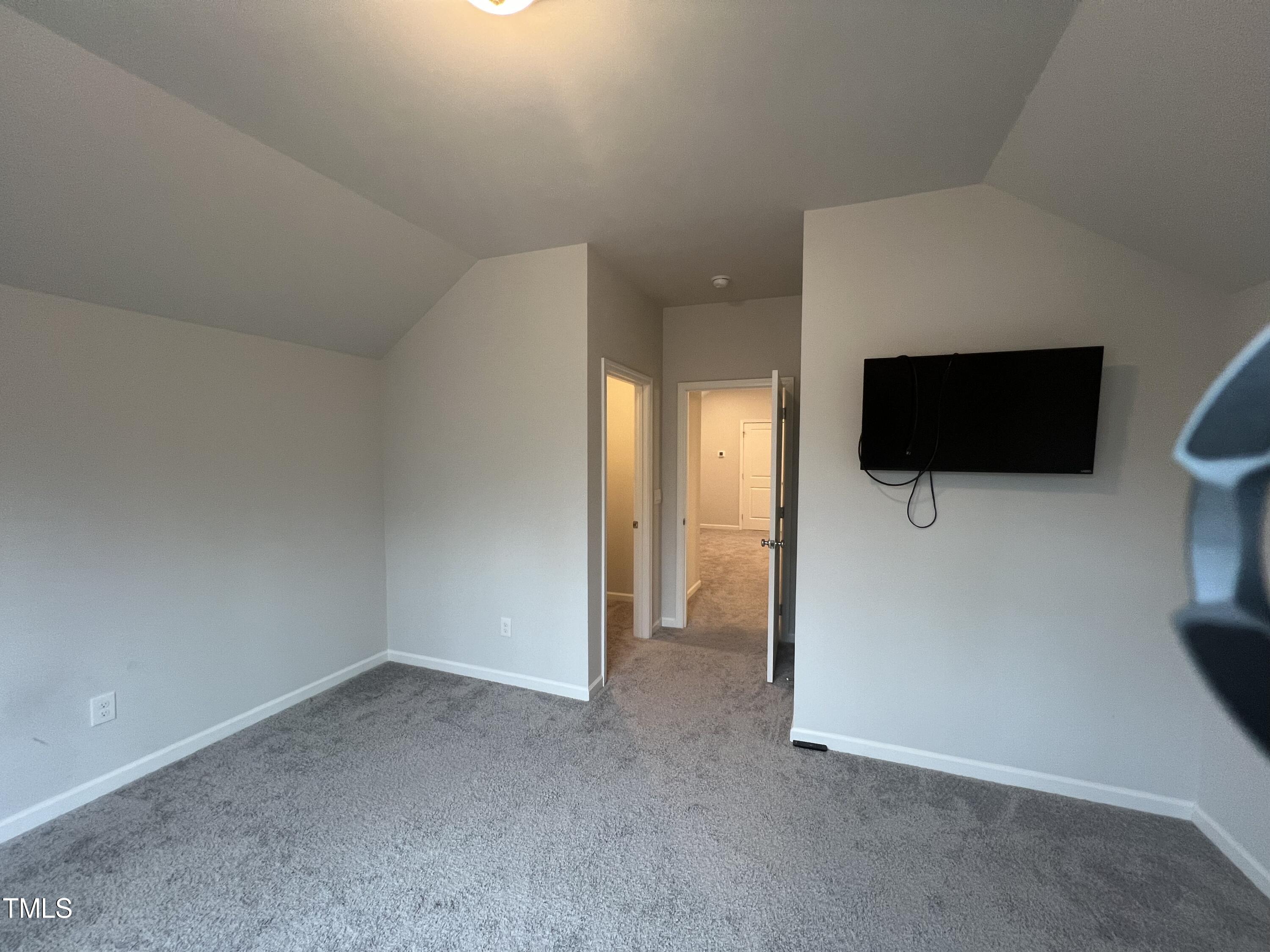 117 Clear Water Road Louisburg, NC 27549 - Photo 32 of 34 a view of empty room with a tv and wooden floor