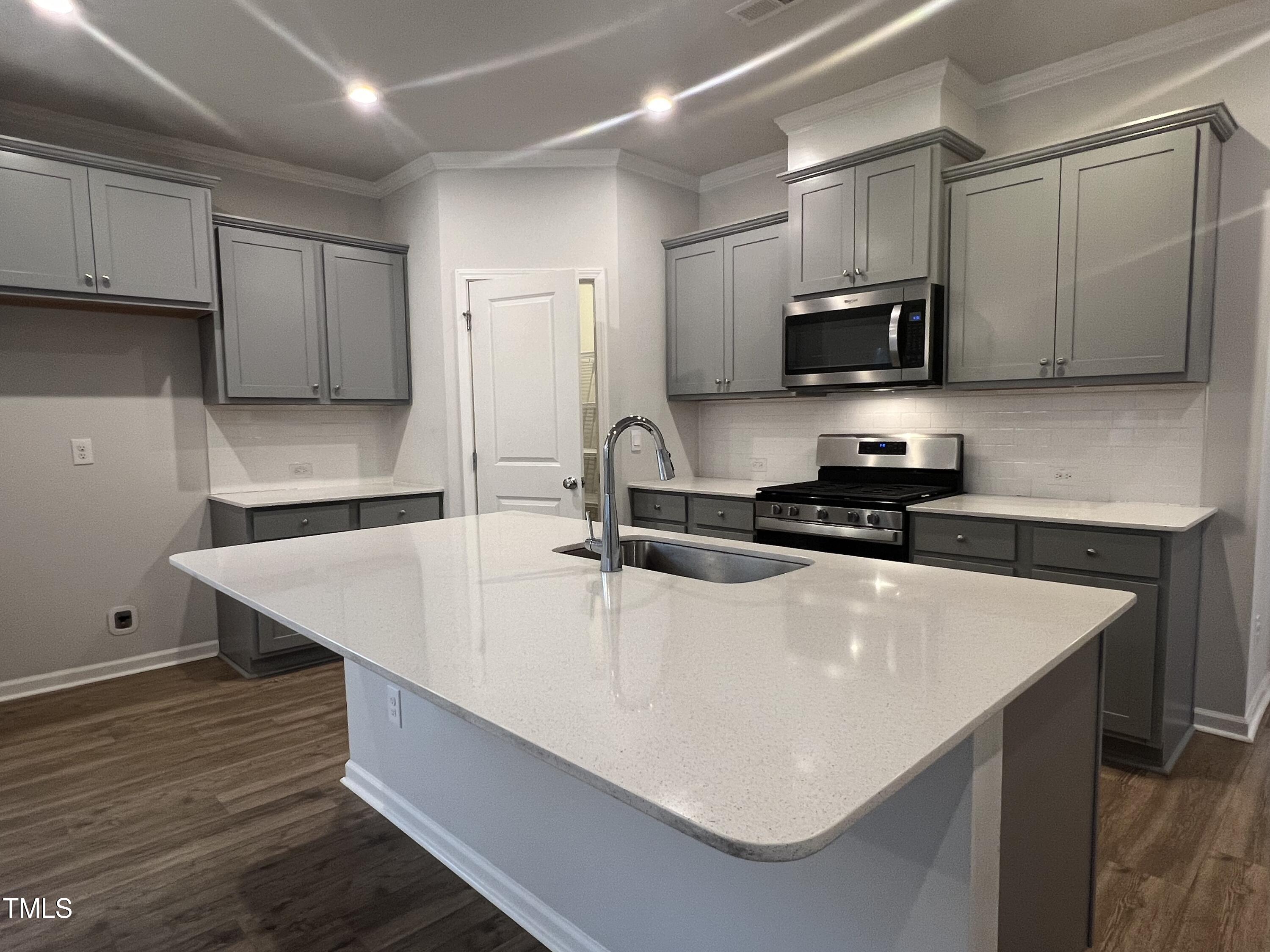 117 Clear Water Road Louisburg, NC 27549 - Photo 9 of 34 a kitchen with stainless steel appliances a sink a stove a microwave and cabinets