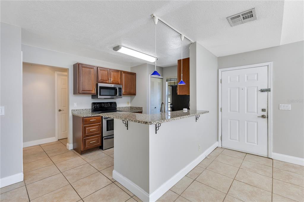955 Forest Ridge Court, Unit 203 Lake Mary, FL 32746 - Photo 12 of 26 a kitchen with stainless steel appliances a refrigerator and a stove