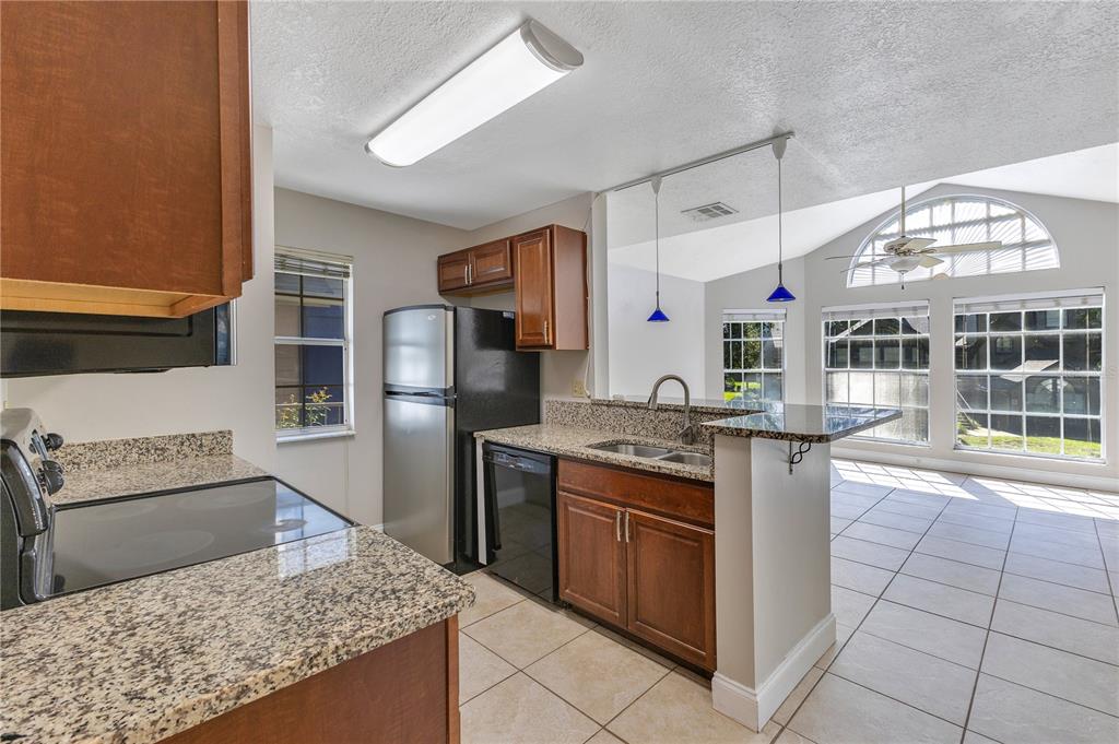 955 Forest Ridge Court, Unit 203 Lake Mary, FL 32746 - Photo 13 of 26 a kitchen with stainless steel appliances granite countertop a sink and a refrigerator