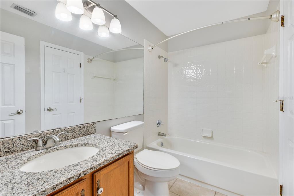 955 Forest Ridge Court, Unit 203 Lake Mary, FL 32746 - Photo 19 of 26 a bathroom with a granite countertop sink toilet mirror and bathtub