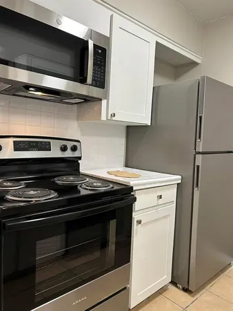 a stove top oven sitting inside of a kitchen