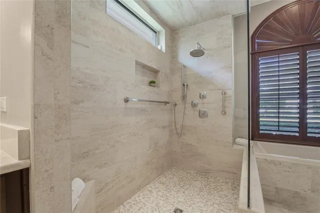 a bathroom with a granite countertop toilet and a shower