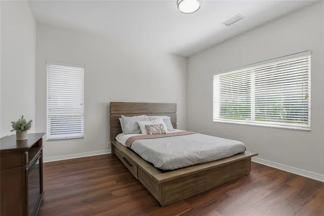 a view of a house with a big yard and palm trees