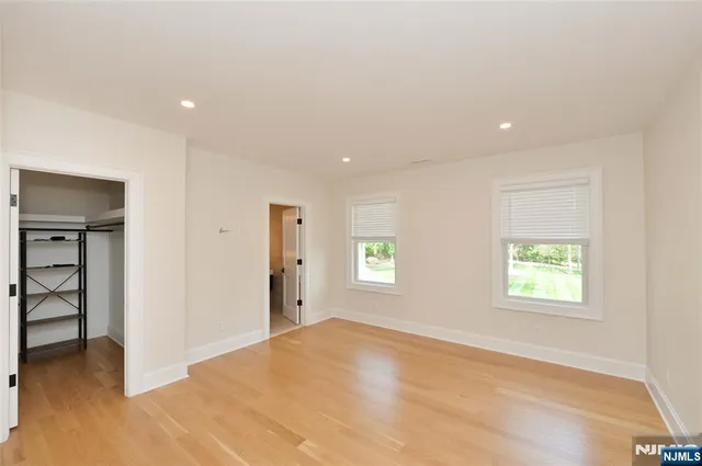 an empty room with windows and closet
