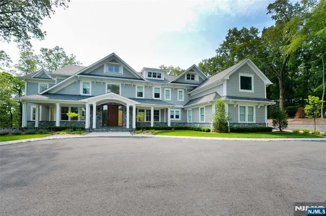 a front view of a house with a yard and trees