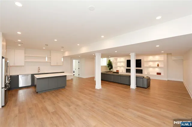 a large white kitchen with a large counter top appliances and cabinets