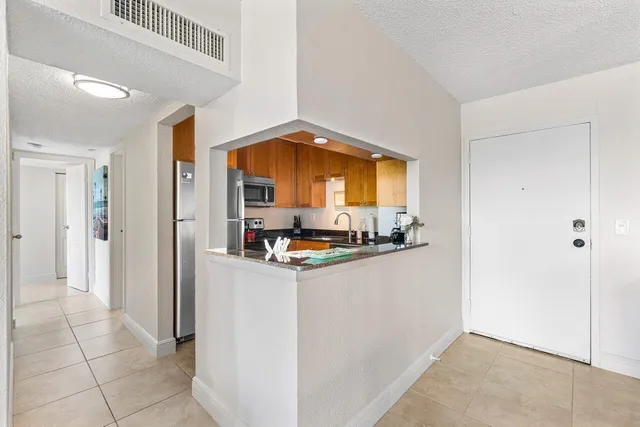 a kitchen with stainless steel appliances granite countertop a refrigerator and a stove