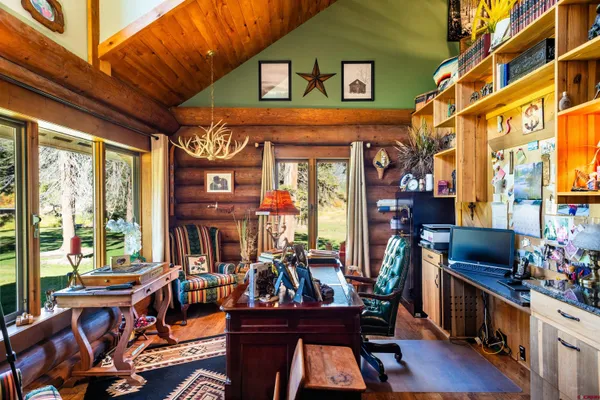 a view of a chairs and table in a living room next to a window