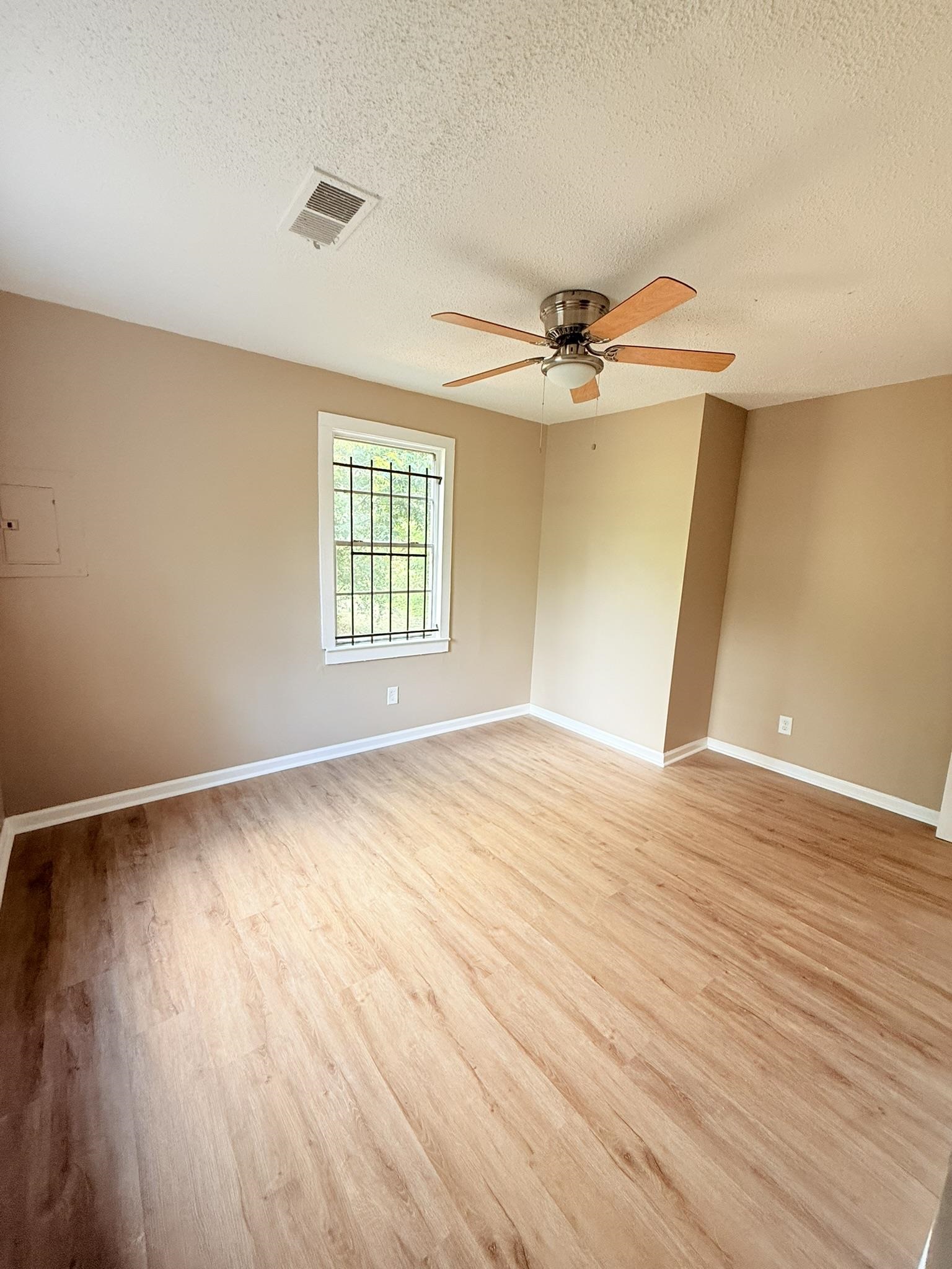 931 Calvin Road Memphis, TN 38109 - Photo 4 of 15 Unfurnished room featuring a textured ceiling, light wood-style flooring, and ceiling fan