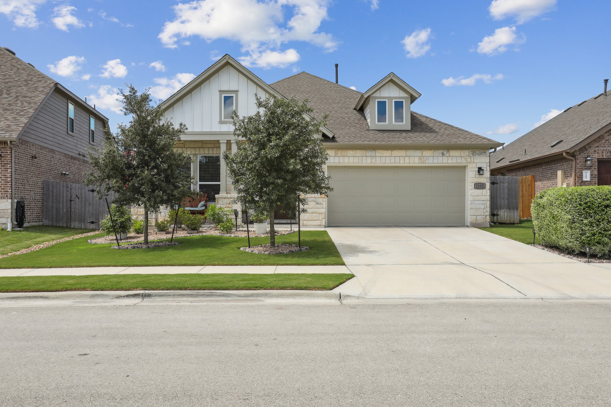 a front view of a house with a yard and trees
