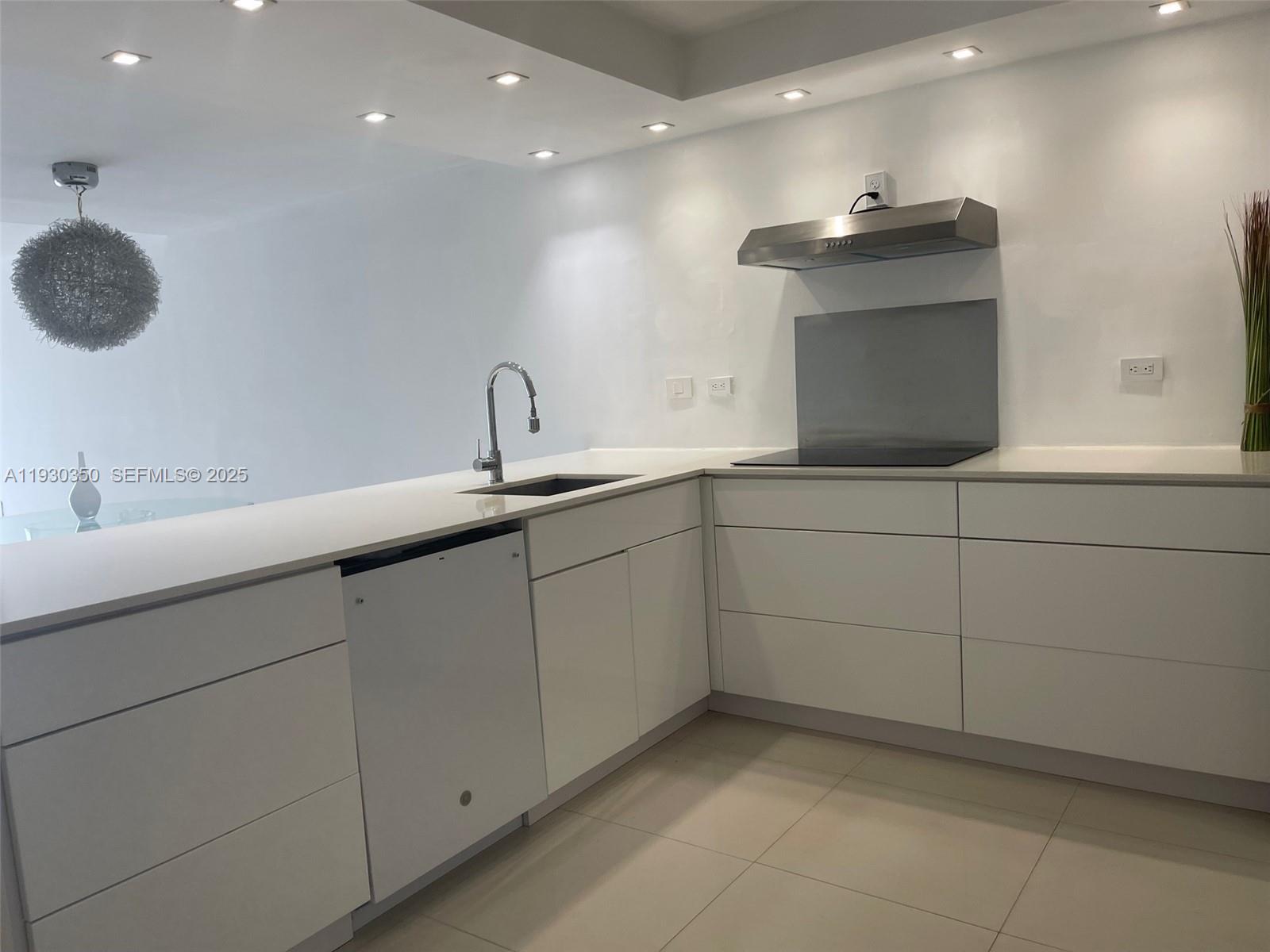 1670 Northeast 191st Street, Unit 2133 Miami, FL 33179 - Photo 3 of 15 a kitchen with a sink and a mirror