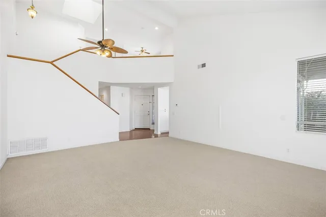 a view of a big room with stairs and a ceiling fan