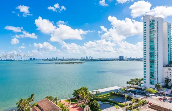 a view of a lake with couches chair and city view