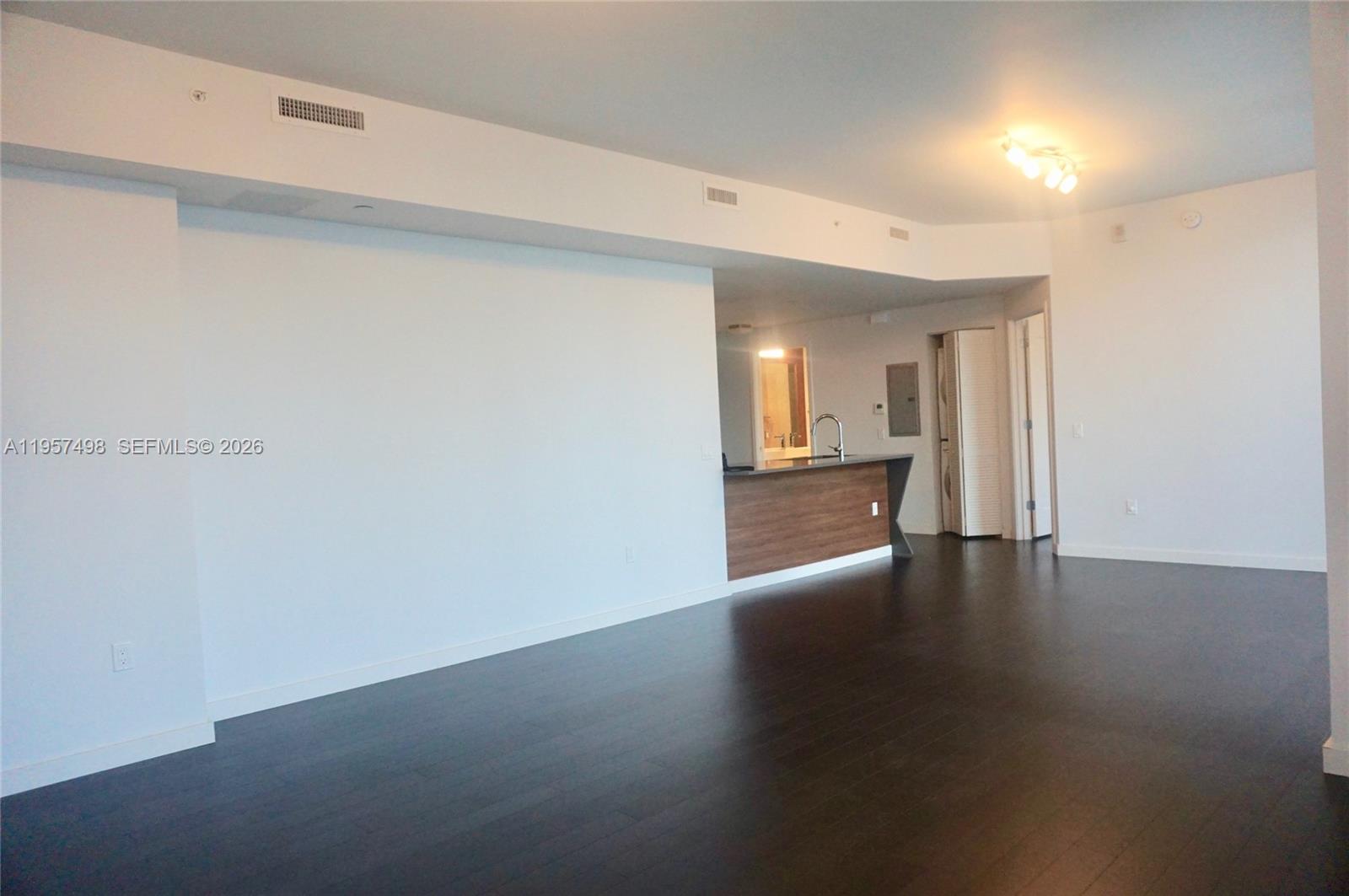 601 Northeast 27th Street, Unit 1706 Miami, FL 33137 - Photo 3 of 10 a view of a hallway with wooden floor and a kitchen