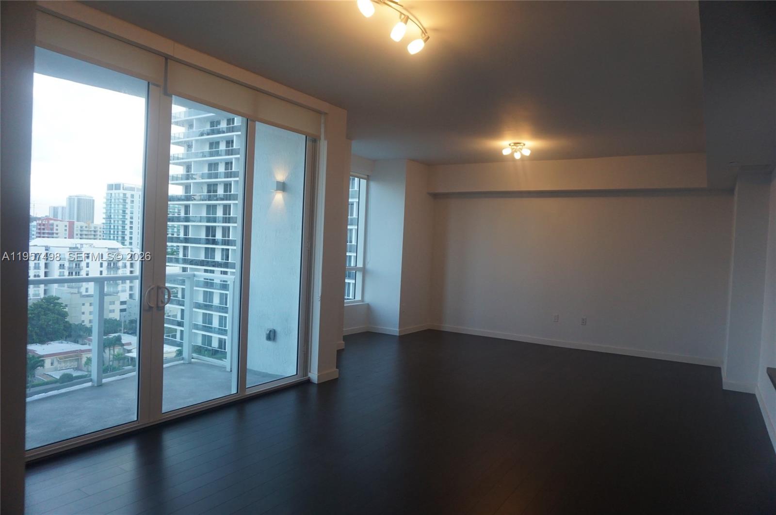 601 Northeast 27th Street, Unit 1706 Miami, FL 33137 - Photo 4 of 10 an empty room with wooden floor and windows