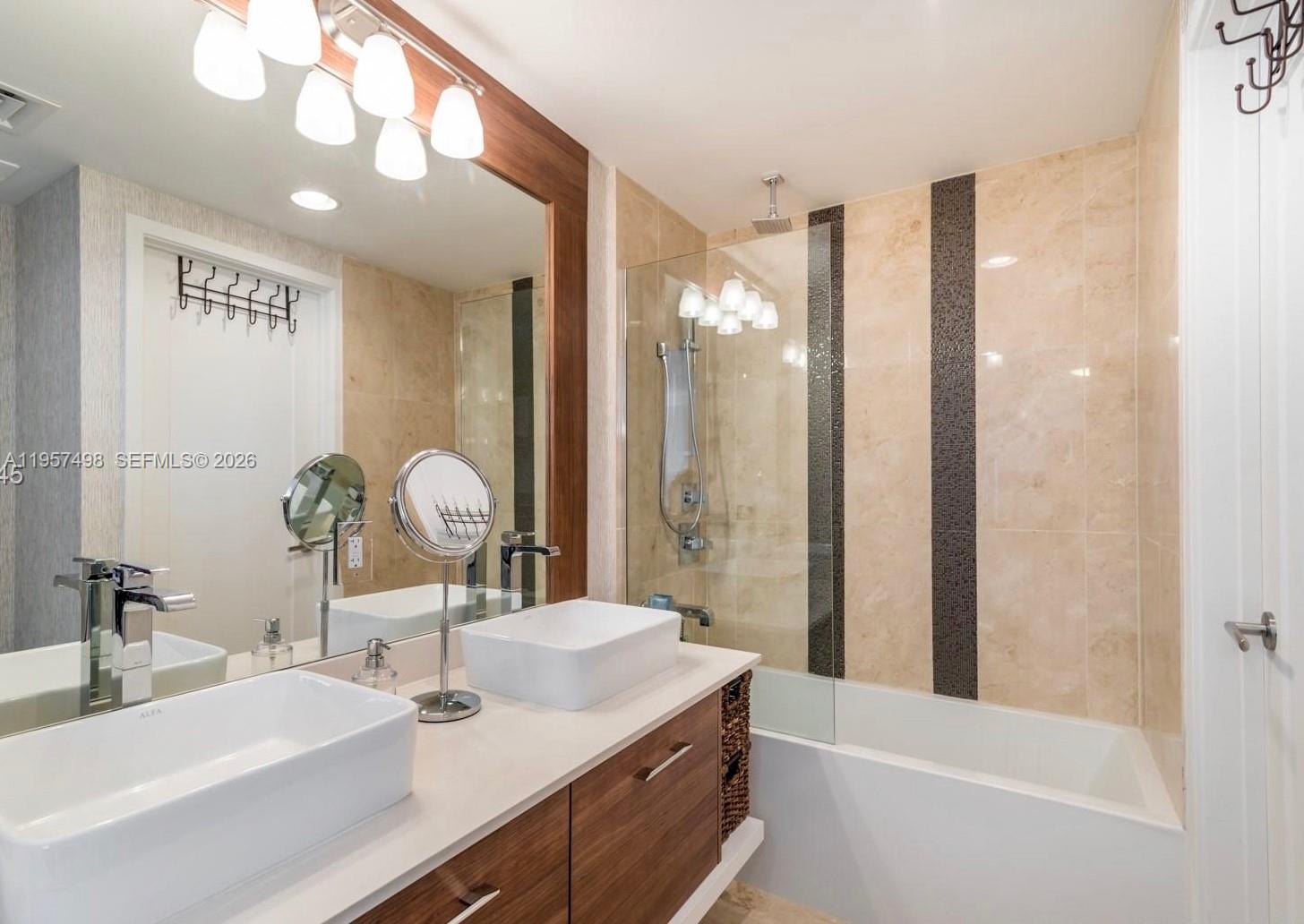 601 Northeast 27th Street, Unit 1706 Miami, FL 33137 - Photo 8 of 10 a bathroom with a sink a large mirror and vanity