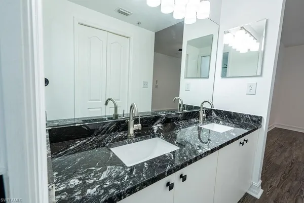 a bathroom with a granite countertop sink and a mirror