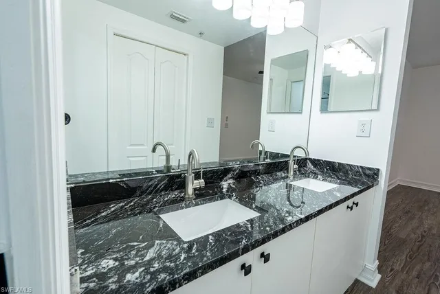 a bathroom with a granite countertop sink and a mirror